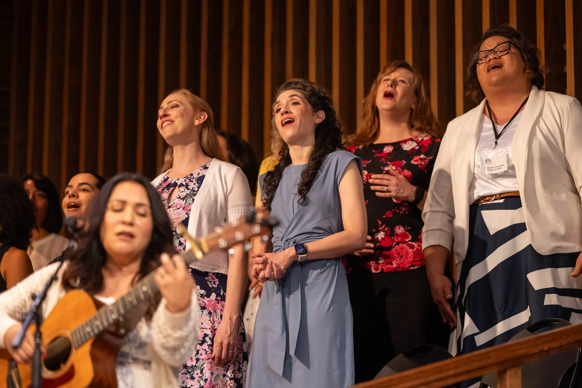 Several alumni standing and singing