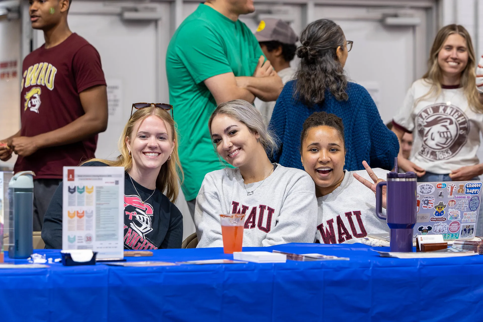 Three people sitting at a display table