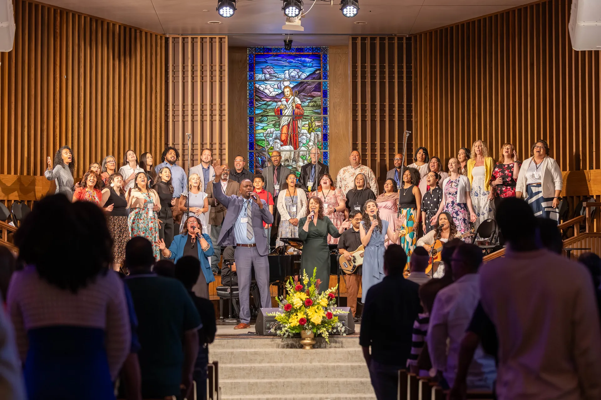 Group photo of alumni in choir on stage