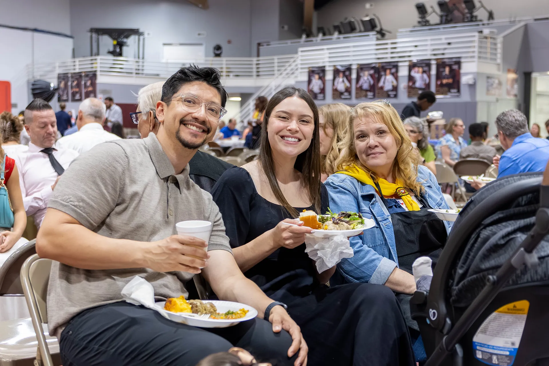 Alumni sitting eating in metal folding chairs