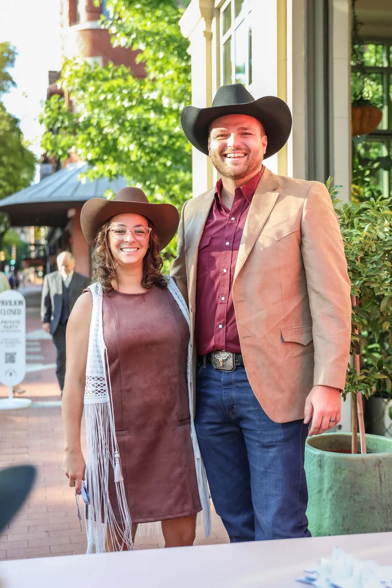 Two people wearing cowboy hats standing in front of a walkway
