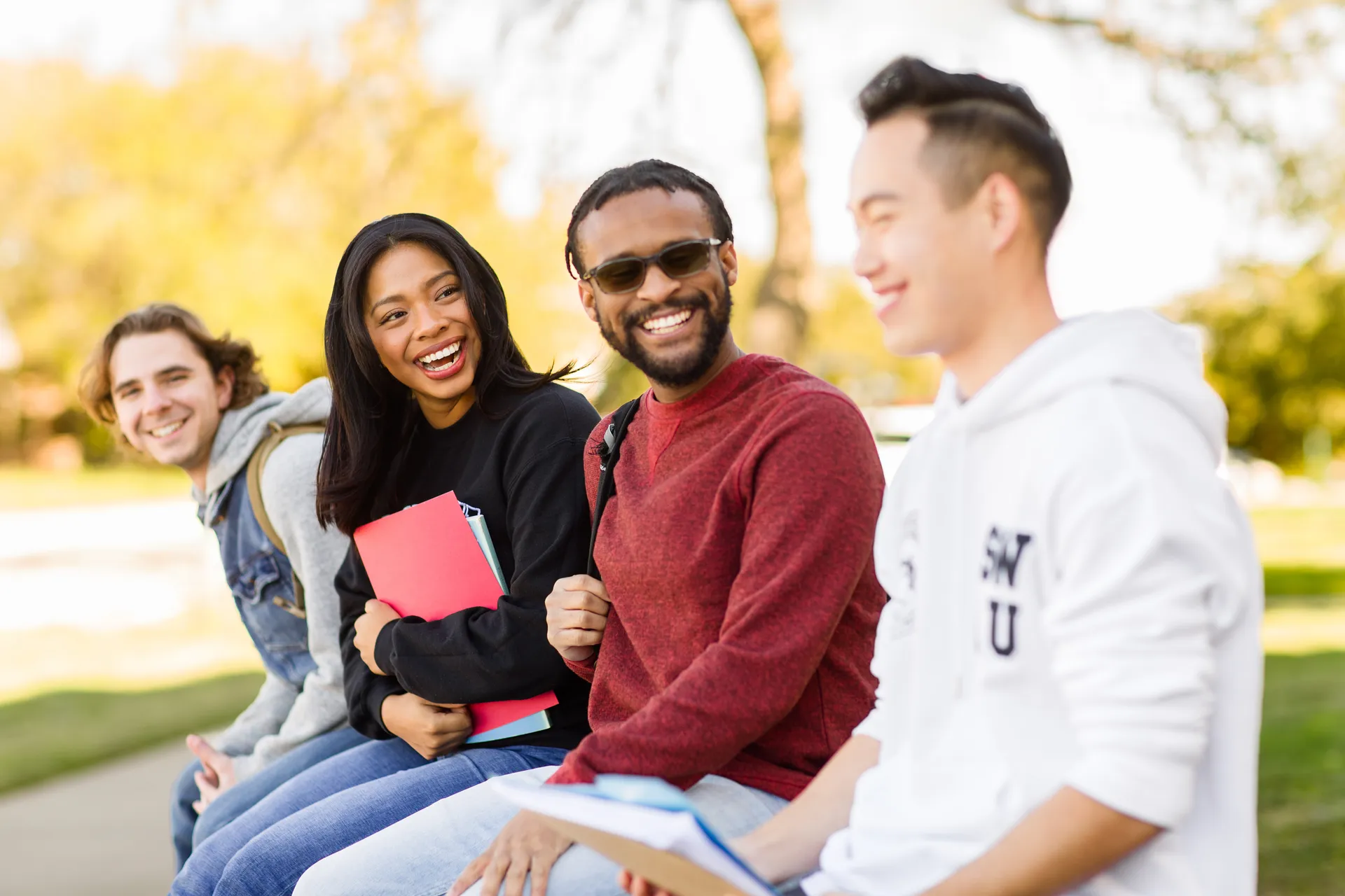 Four students sitting in a line