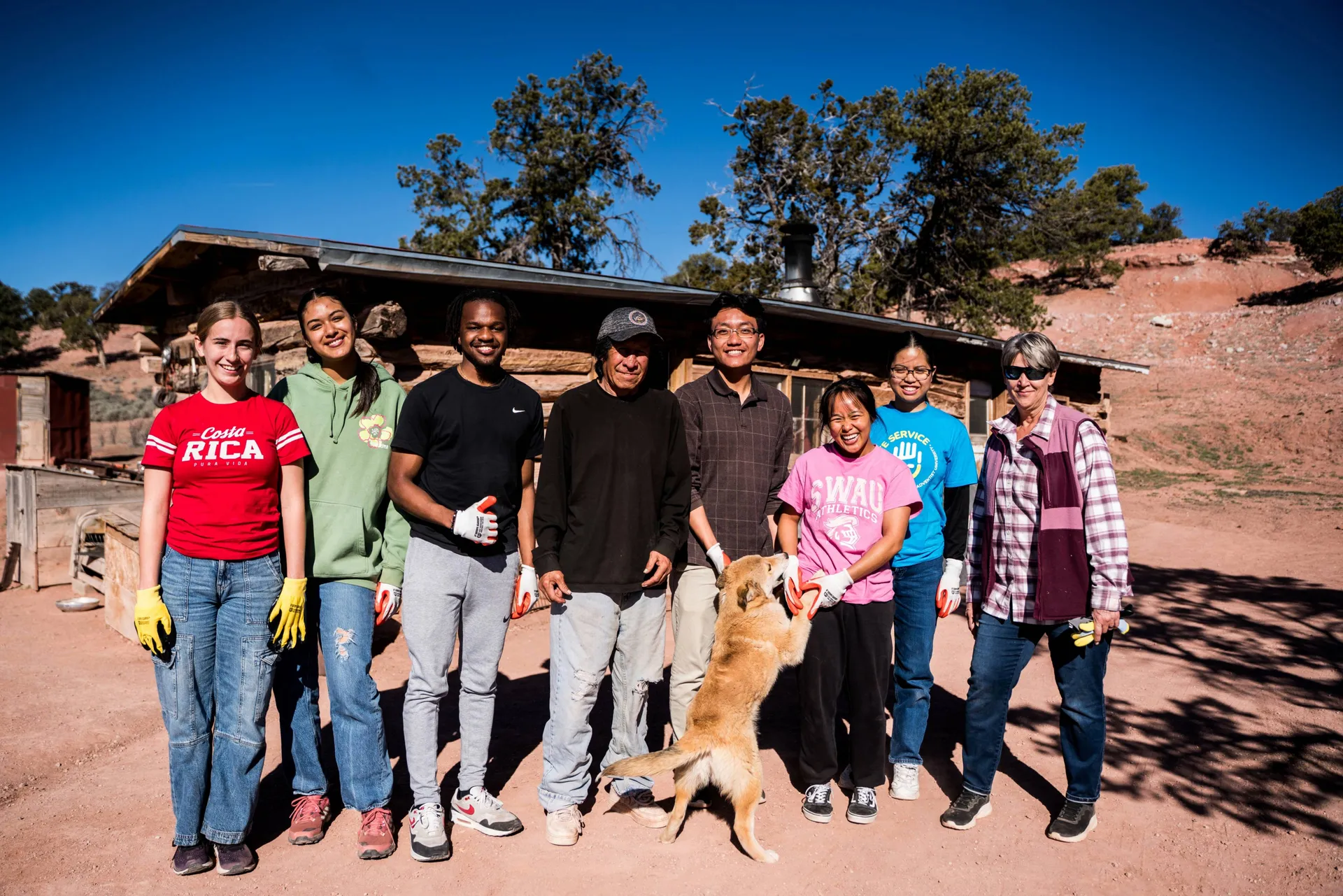 Group photo of students with a dog in front