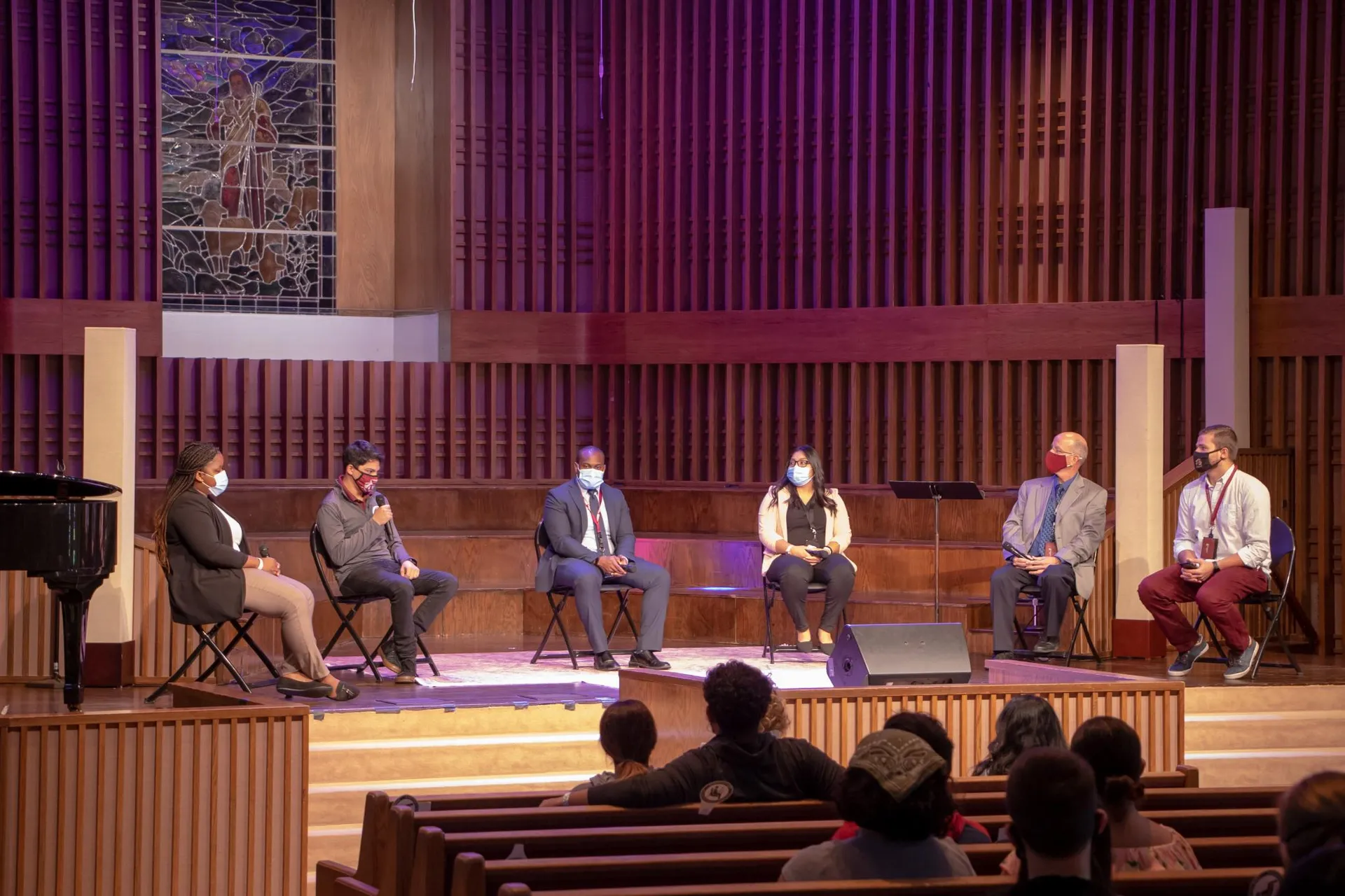 Group of 4 Southwestern Adventist University faculty/staff and 2 students sitting socially distanced on a stage