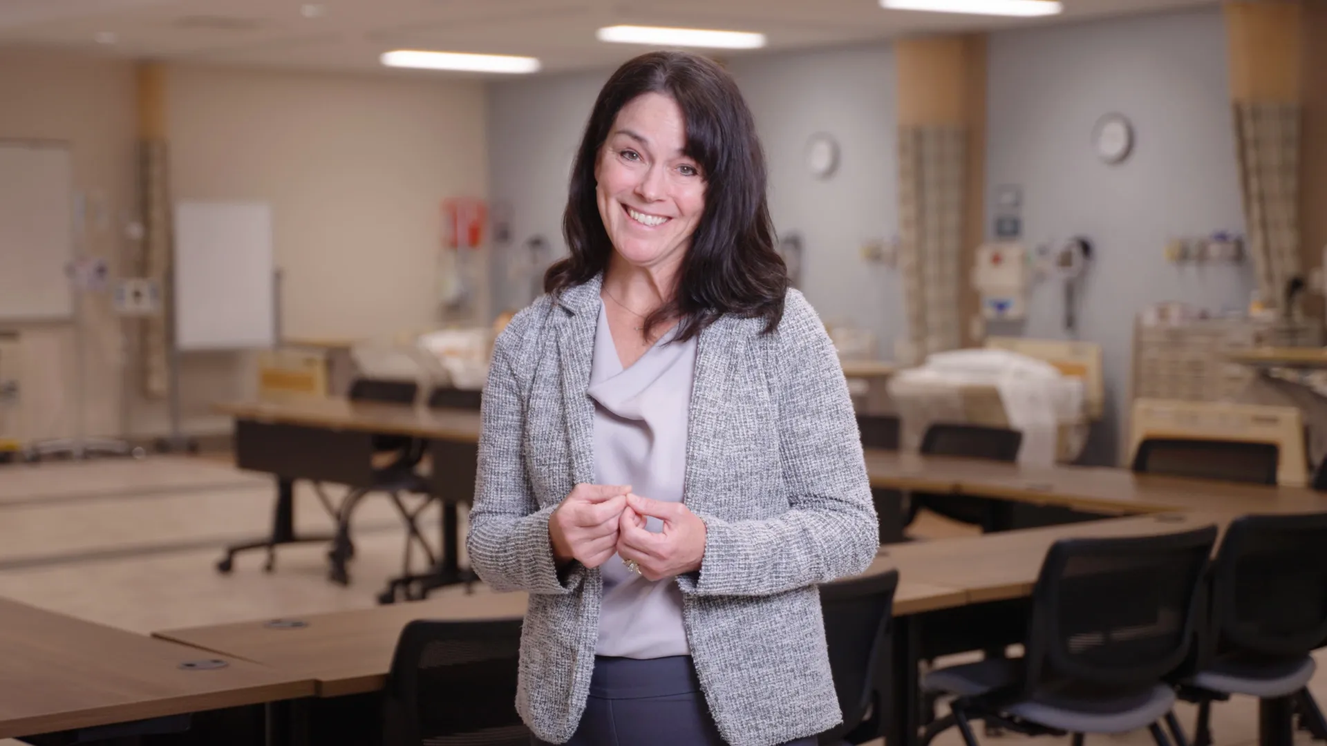 A teacher standing in front a nursing simulation classroom