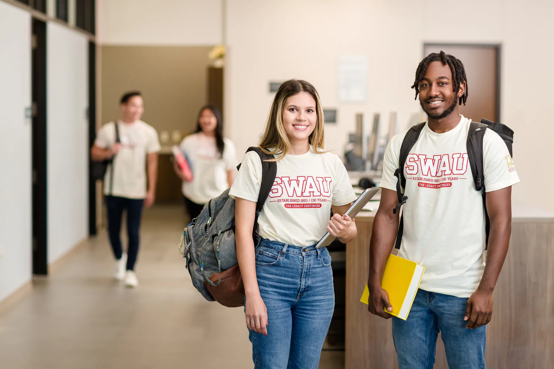 Two students wearing SWAU shirts standing together