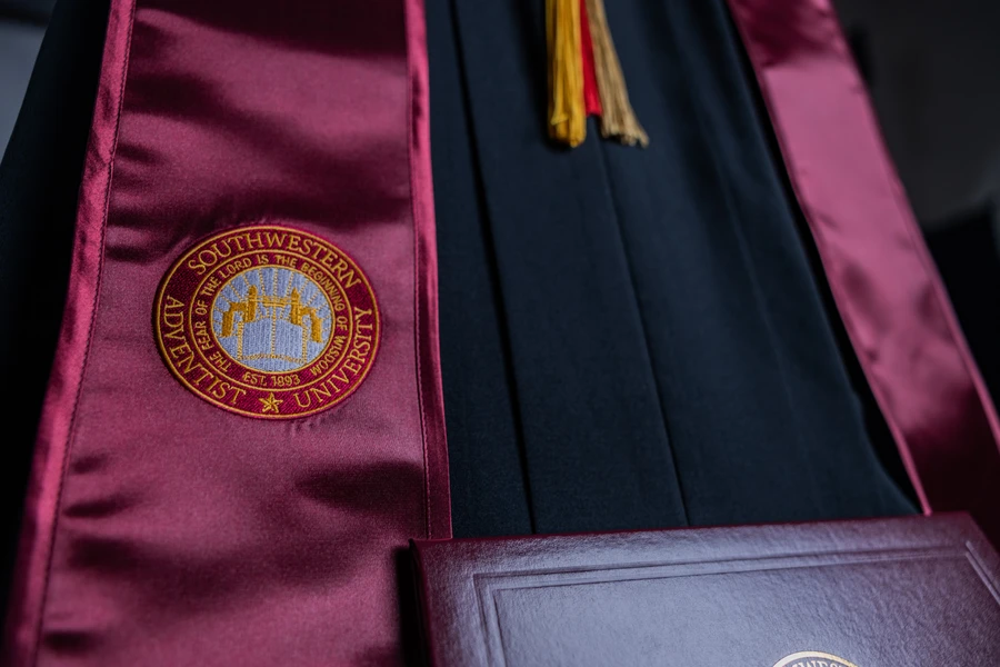 SWAU graduation sash, tassle, diploma and gown aesthetic shot