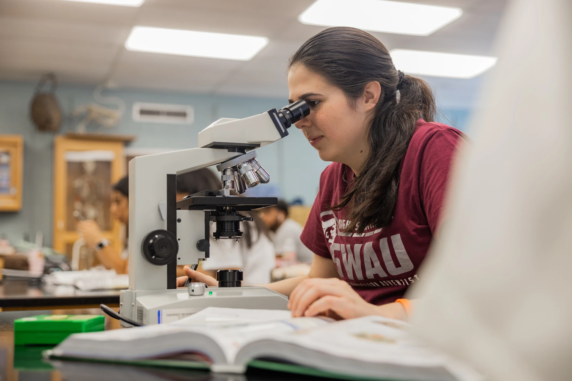 SWAU student anatomy and physiology lab with microscope and textbook