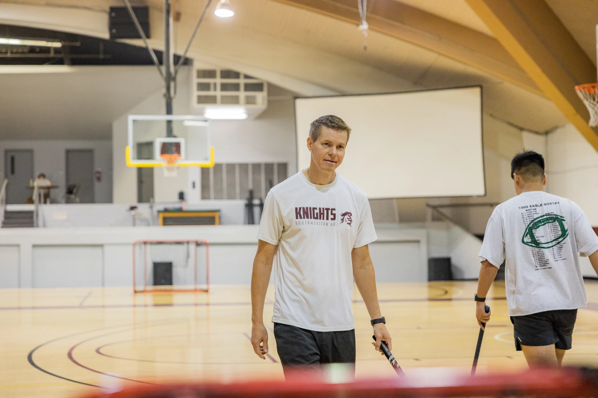 SWAU professor and student for health and fitness floorball at the gym