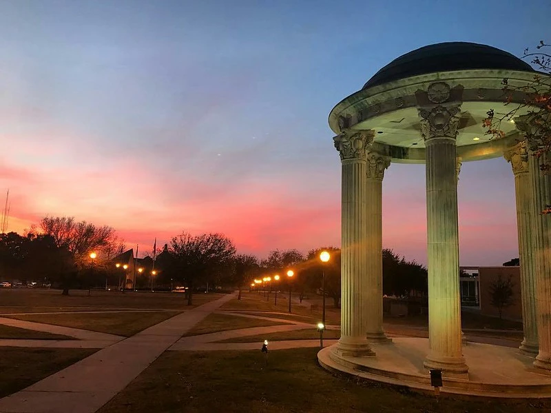 The sunsets paints the sky with blue, pink and purple colors behind the rotunda